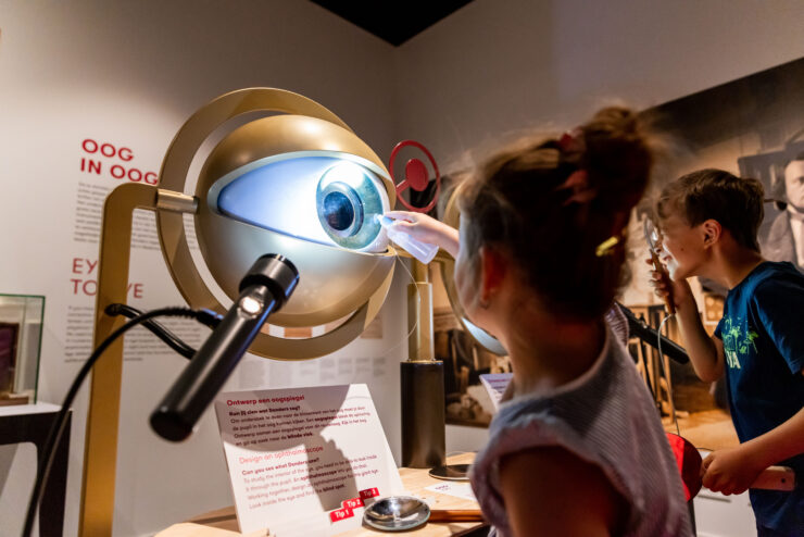 Kinderen doen oogonderzoek in het museum